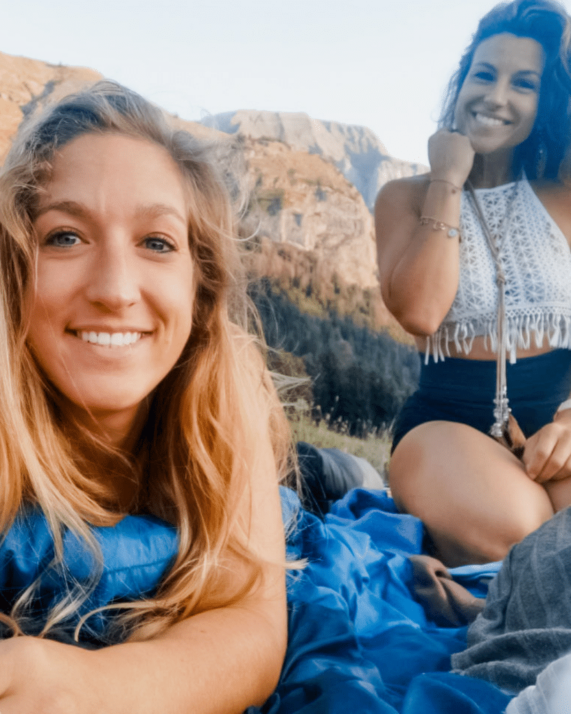 Deux femmes souriantes et complices en pleine nature rocheuse – BYOU L'Expérience