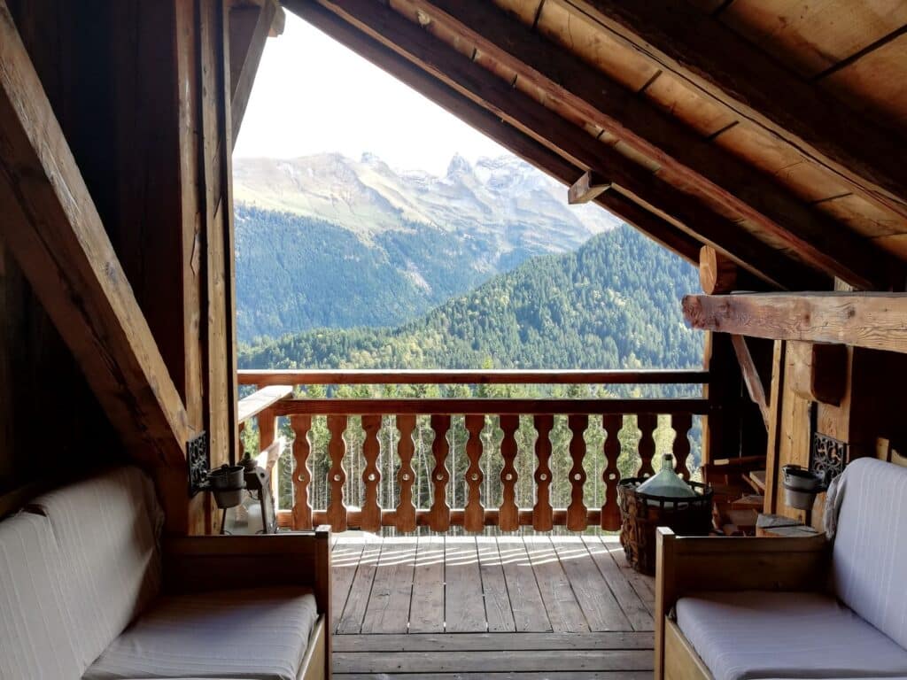 Balcon en bois avec vue panoramique sur les montagnes en Haute-Savoie au Gîte du Passant, espace de contemplation et de reconnexion.